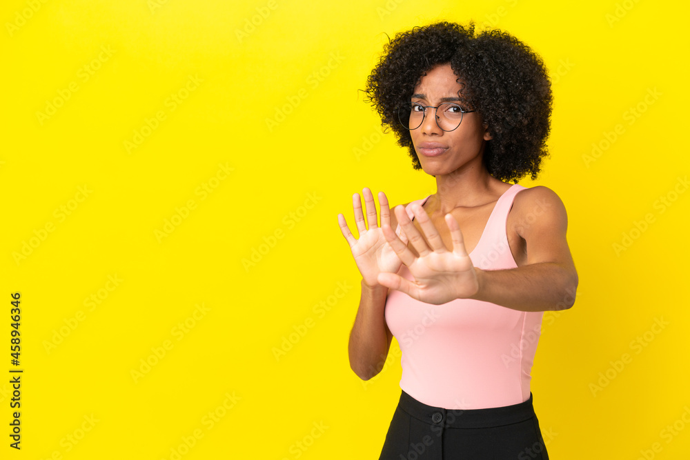 Young African American woman isolated on yellow background nervous stretching hands to the front Young African American woman isolated on yellow background nervous stretching hands to the front