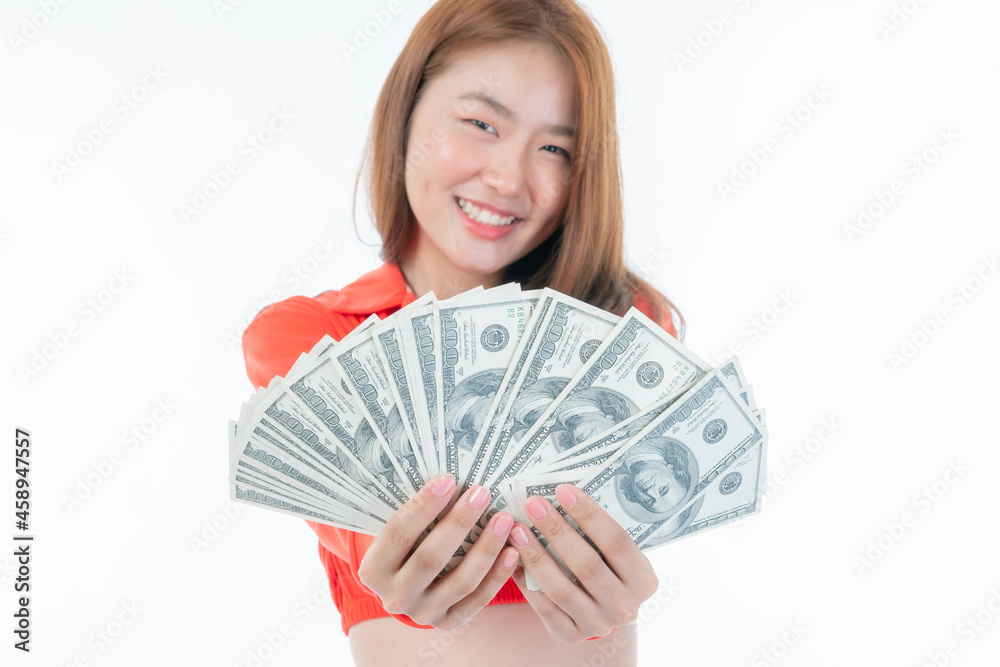 selective focus - Successful beautiful Asian business young woman cute girl holding money US dollar bills in hand isolated on white background , business concept selective focus - Successful beautiful Asian business young woman cute girl holding money US dollar bills in hand isolated on white background , business concept