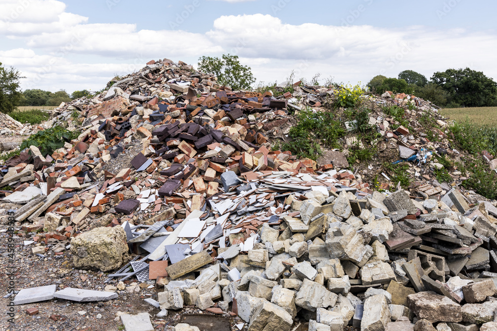 A pile of builders rubble dumpde in the countryside.