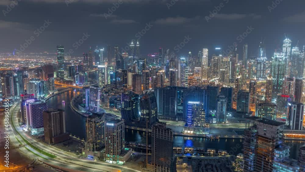 Skyline with modern architecture of Dubai business bay towers night timelapse. Aerial view