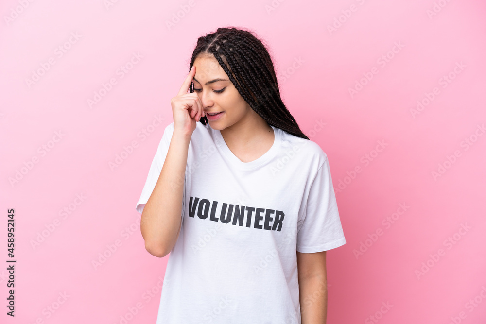 Teenager volunteer girl with braids isolated on pink background laughing Teenager volunteer girl with braids isolated on pink background laughing