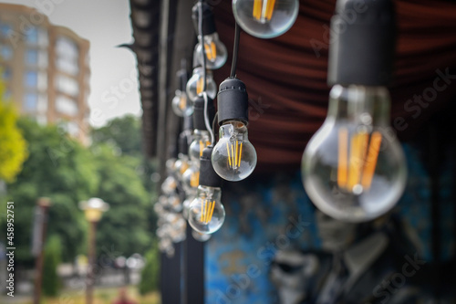 Decorative retro light bulbs for decoration in outdoor cafe. Selective focus.
