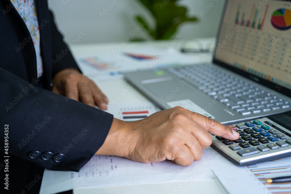 Asian accountant working and analyzing financial reports project accounting with chart graph in modern office, finance and business concept. Asian accountant working and analyzing financial reports project accounting with chart graph in modern office, finance and business concept.