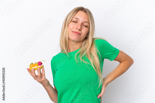 Young caucasian woman holding a tartlet isolated on white background suffering from backache for having made an effort