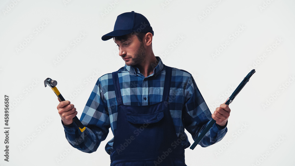 Obraz premium Handyman holding hammer and pipe wrench isolated on white