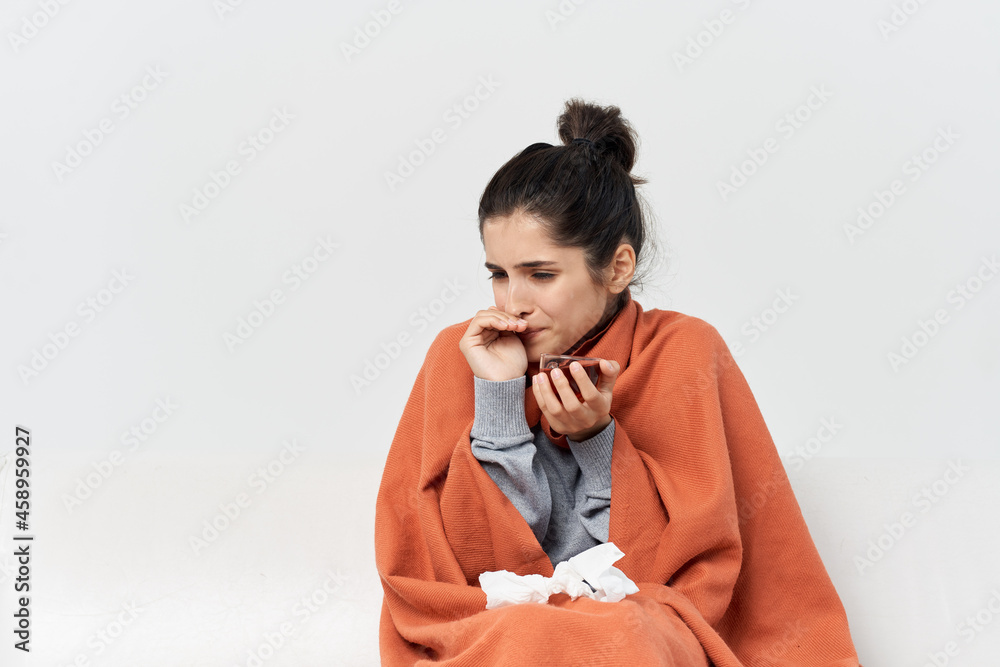 woman covering herself with a blanket at home health problems cold woman covering herself with a blanket at home health problems cold