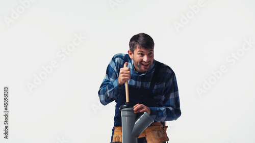 Smiling workman with plunger and plastic pipe isolated on white