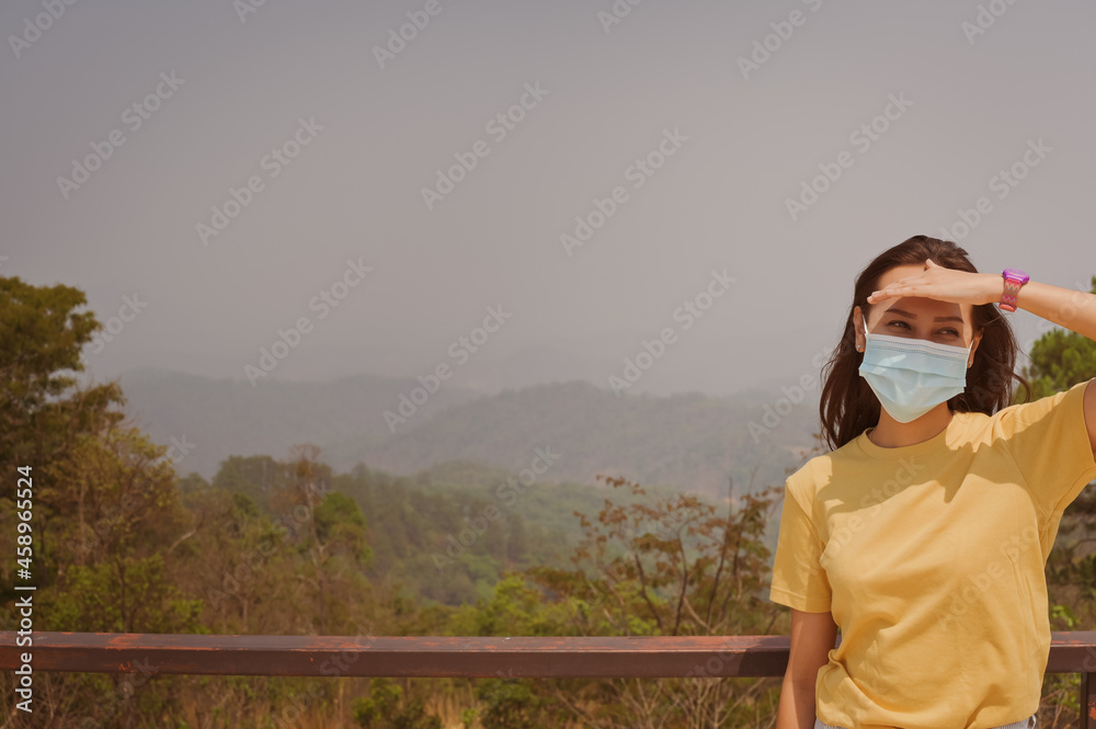 Front view point of young women traveller wearing surgical protection mask standing outdoor in daytime , travel and inspiration concept