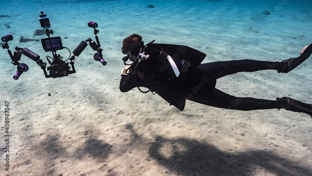 Professional diver, underwater cinematographer filming in coral reef of Caribbean Sea around