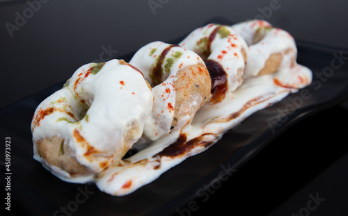 Dahi vada or bhalla is a type of chaat originating from the Indian and popular throughout South Asia. It is prepared by soaking vadas in thick dahi or curd. photo