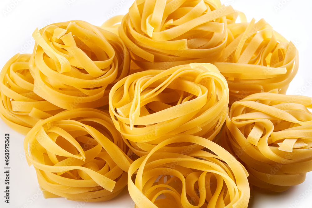Italian egg pasta nest close-up. Fettuccine background Italian egg pasta nest close-up. Fettuccine background