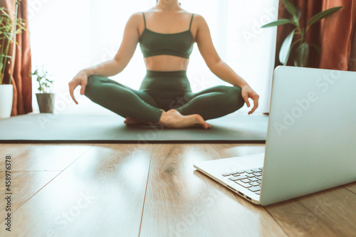 woman do yoga near laptop online learning teaching