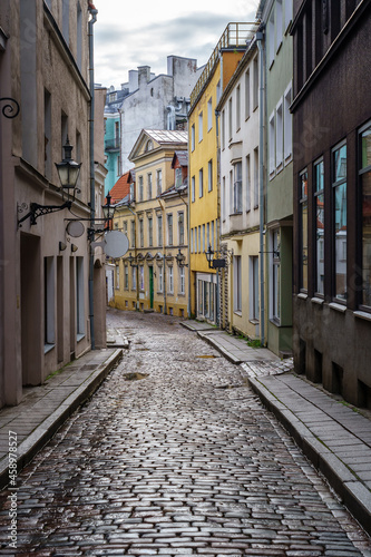 Narrow alley in medieval town with reflections on the ground from the rain.