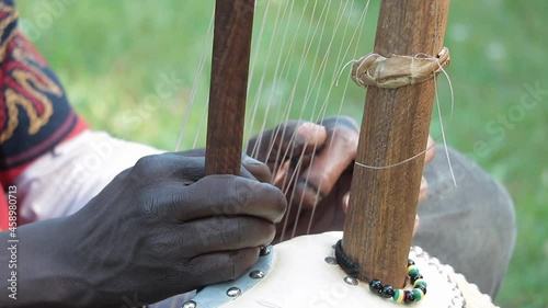 African artist playing an African instrument in a city park