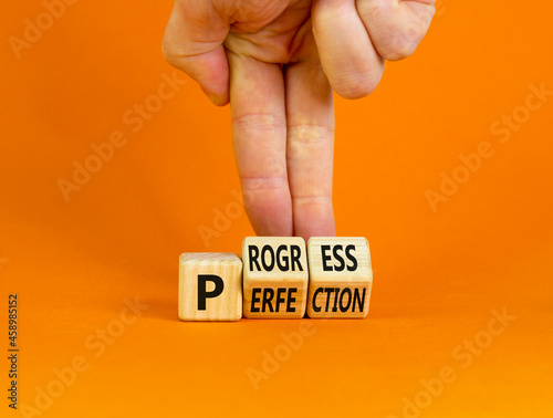 Progress or perfection symbol. Businessman turns cubes and changes the concept word 'perfection' to 'progress' on a beautiful orange background. Copy space. Business, progress or perfection concept.