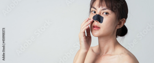 Beautiful female model with mask charcoal deep cleansing nose pore strip on fresh clean skin.