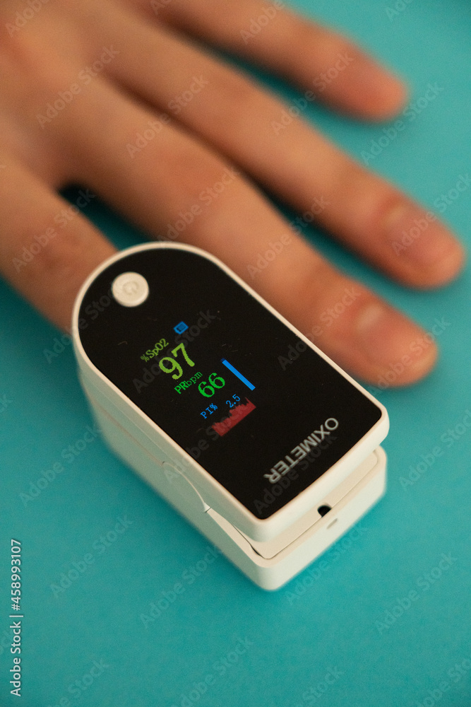 Person measuring their oxygen level using an oximeter. Person measuring their oxygen level using an oximeter.