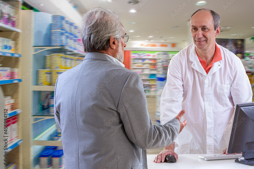 Obraz premium Pharmacist and senior customer discussing medications.