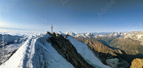 Dom 4545m . Highest mountain in Switzerland. Summit cross, valais alps. mountaineering, rock climbing. blue sunny sky photo