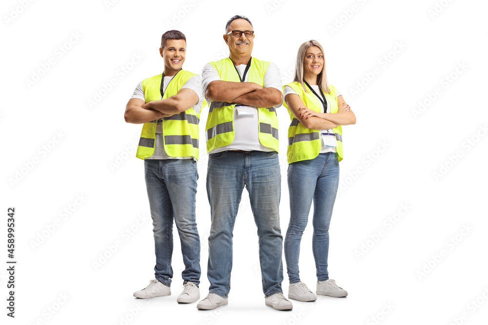 Full length portrait of two men and a woman wearing a reflective safety vests and posing with crossed arms Full length portrait of two men and a woman wearing a reflective safety vests and posing with crossed arms