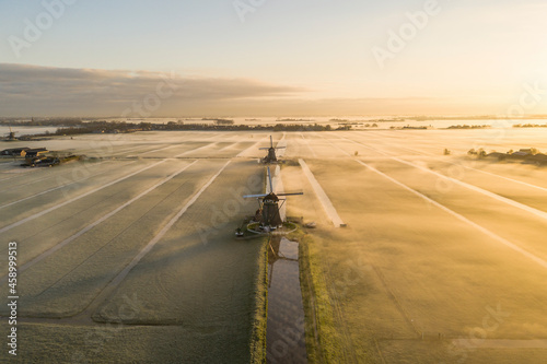 Aerial view of windmills in morning fog during sunrise in Aarlanderveen, Alphen aan den Rijn, Netherlands. photo