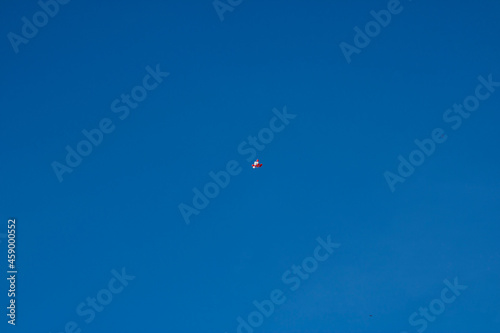White and Red Balloons Floating in the Middle of a Clear Blue Sky