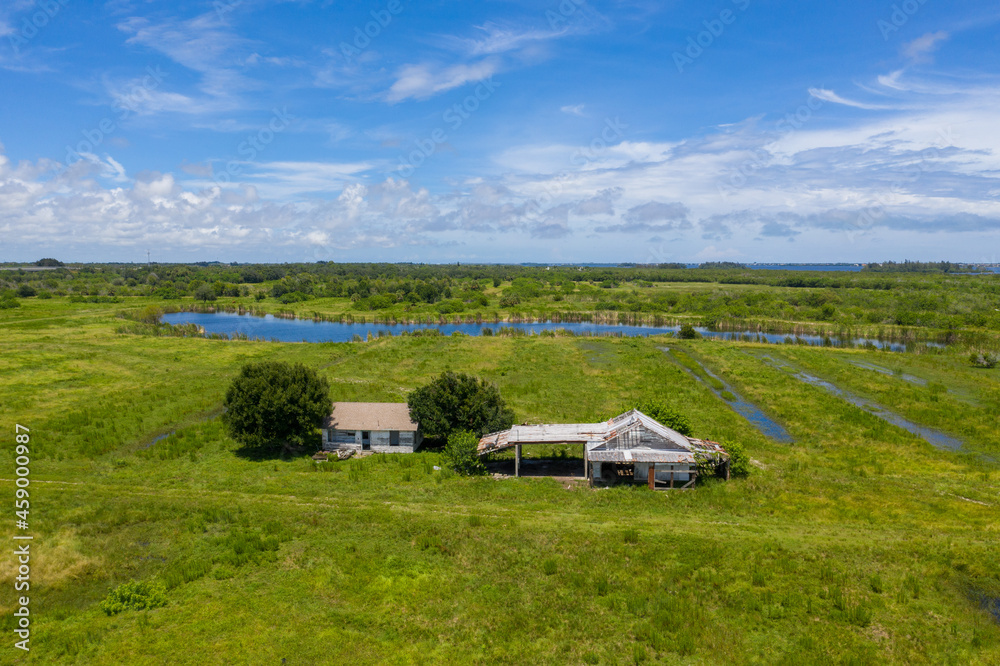 Aerial view of an abandoned farm house near Old Dixie Highway with a lake in background, St. Lucie County, Florida, United States. Aerial view of an abandoned farm house near Old Dixie Highway with a lake in background, St. Lucie County, Florida, United States.