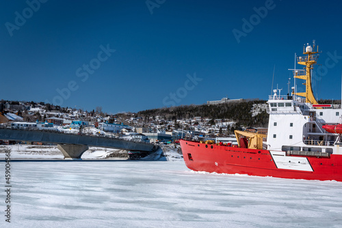 Coast Guard icebreaker at work near small coastal community in eastern Quebec, Canada. photo