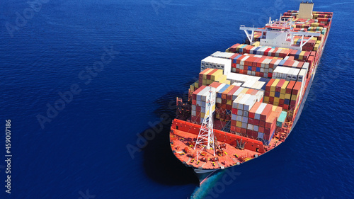 Aerial drone photo of bow from huge container tanker ship cruising deep blue sea