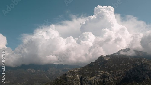 high mountain range surrounded by  clouds under the bright blue sky Wide angle aerial panorama, Babadag 1700m, Pine forest on the slopes photo