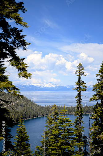 A view to lake Tahoe with blue sky and white fluffy clouds and mountains on the background