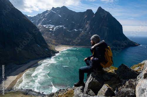 Hiker with backpack enjoying sunset landscape in Lofoten Norway