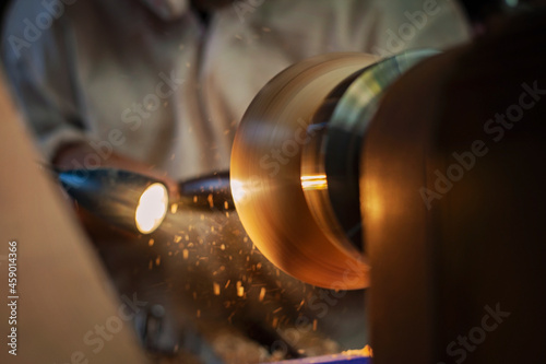 A wooden bowl being turned by a man on a woodturning lathe.A craftsman at work.Sawdust is flying. photo