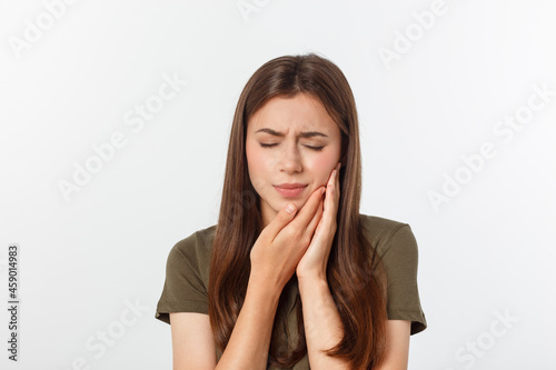 Teen woman pressing her bruised cheek with a painful expression as if she is having a terrible tooth ache photo