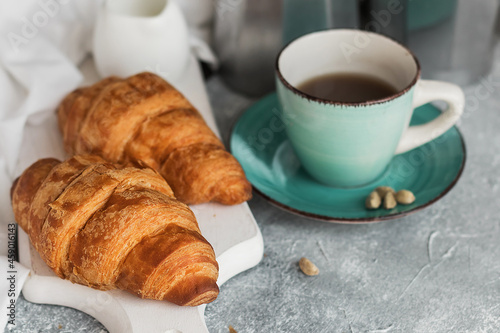 Fototapeta Naklejka Na Ścianę i Meble -  French breakfast. Freshly baked croissants and a cup of coffee on a white wooden board. Copy space. 