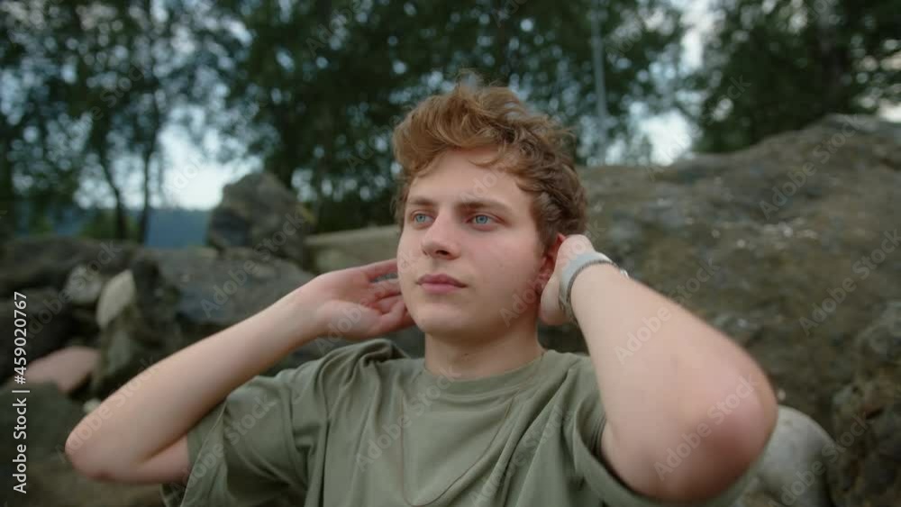 Thoughtful blond colored-eyed young man looking to his left and right outside Thoughtful blond colored-eyed young man looking to his left and right outside