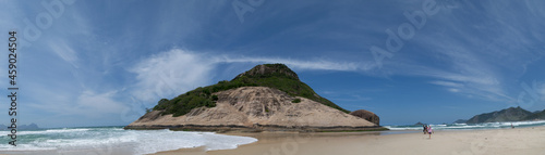 Mountain known as "pedra do Pontal", located on Praia do Pontal in the district of Recreio dos Bandeirantes, Rio de Janeiro, Brazil. Where you can see the mountain, the beach, and the people on the sa