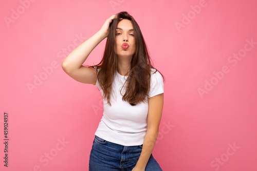 Photo shot of cute nice charming gorgeous attractive pretty youngster happy woman wearing white t-shirt for mockup isolated over colorful background with copy space and giving kiss