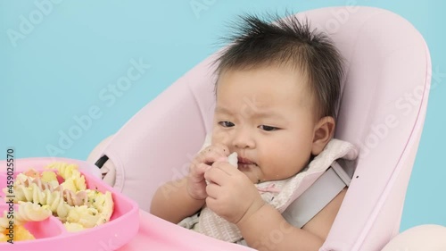 4K Close up slow motion Asian baby eating soft food by hand on baby chair