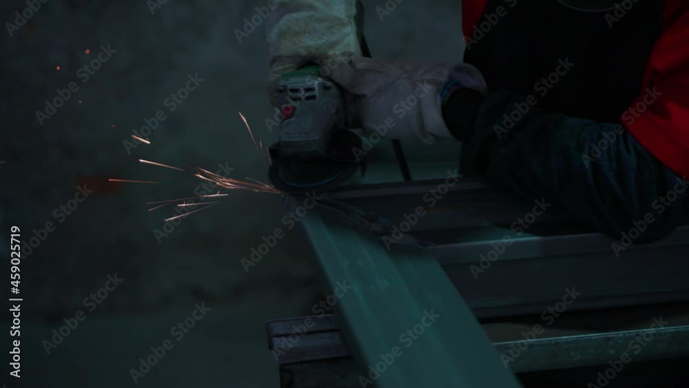 close up worker hand wear glove holding grinder griding metal in the factory close up worker hand wear glove holding grinder griding metal in the factory