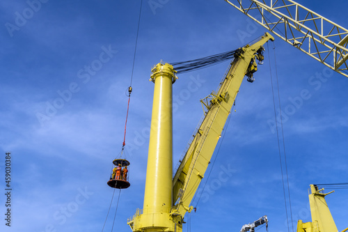 Offshore crews being transferred to a constrution work barge via a personal transfer basket at an oil field photo