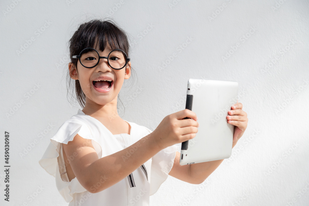 Shocked and surprised little girl on the internet with digital tablet computer concept for amazement, astonishment, making a mistake, stunned and speechless or seeing something he should not see Shocked and surprised little girl on the internet with digital tablet computer concept for amazement, astonishment, making a mistake, stunned and speechless or seeing something he should not see