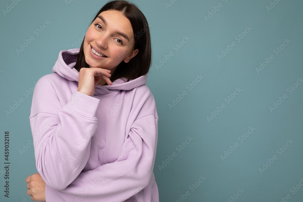Photo of beautiful positive smiling adult woman wearing stylish clothes standing isolated on colorful background with copy space looking at camera