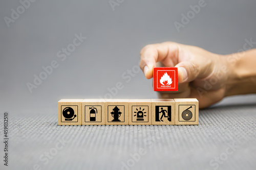 Fire prevention, Cube wooden toy block stack with prevent icon with door exit sing or fire escape with fire extinguisher and emergency protection symbol for safety and rescue in the building.