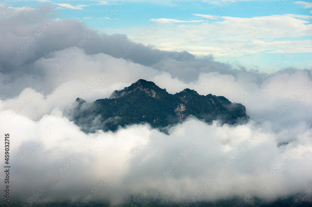 Beautiful Landscape in the morning time during sunrise with fog above the mountain, White fluffy clouds moving softly on cloudy, Pang puay Mae moh Lampang, Thailand.