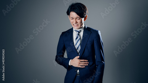 Foto 腹痛を感じるビジネスマン