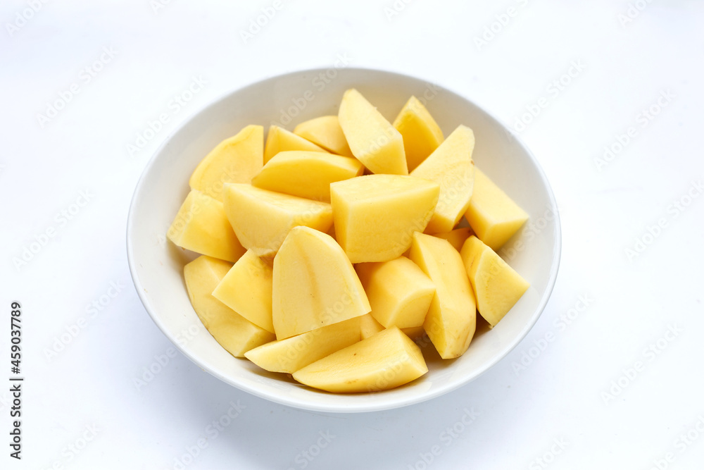 Fresh potato cut into pieces in bowl on white background. Fresh potato cut into pieces in bowl on white background.