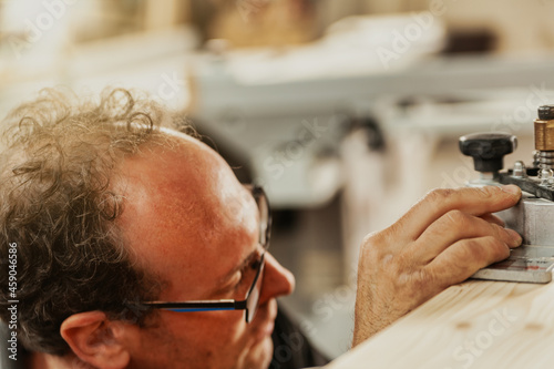 Artisan adjusting precision machinery in a workshop