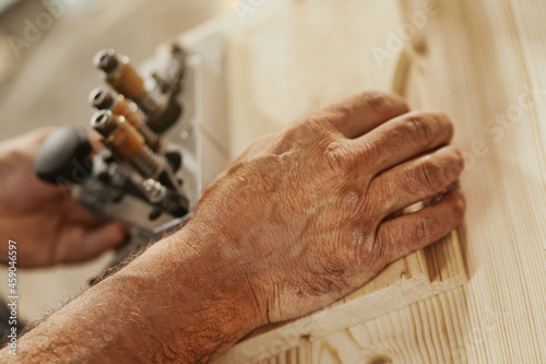 Hand of a carpenter working on cabinetry in a workshop
