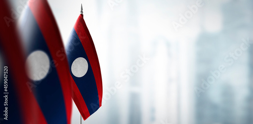 Small flags of Laos on a blurry background of the city